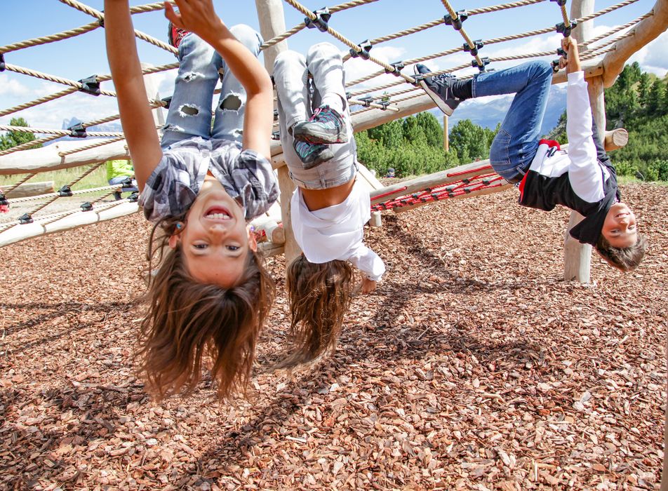 Bambini che si divertono appesi a una struttura di corde in un parco giochi all'aperto.