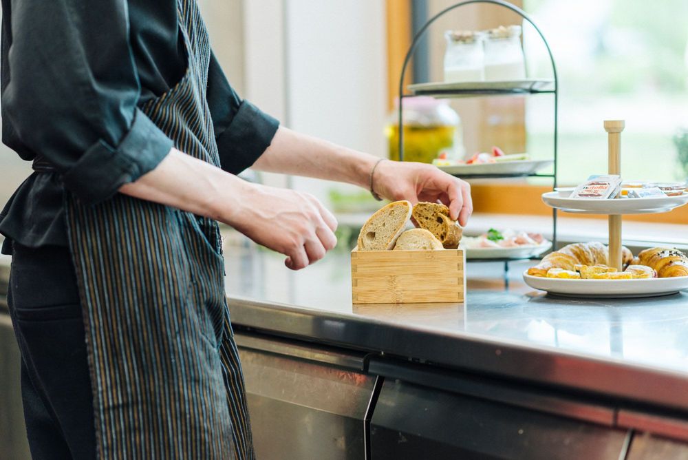 Persona che sistema fette di pane in una scatola in cucina Persona che sistema fette di pane in una scatola in cucina