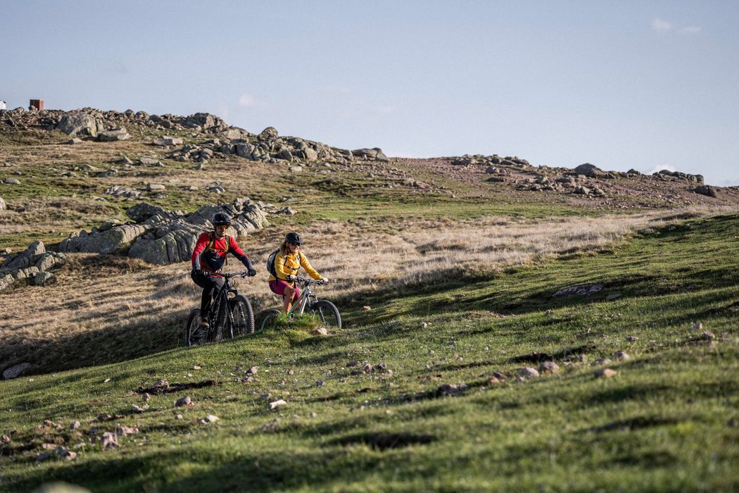 Due persone in bicicletta su un sentiero di montagna.