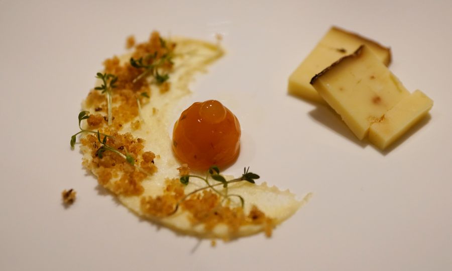 Piatto gourmet con mousse, gelatina arancione, briciole e fette di formaggio