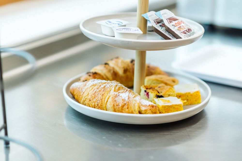 Vassoio a due piani con croissant, dolcetti e confezioni di crema spalmabile e marmellata. Vassoio a due piani con croissant, dolcetti e confezioni di crema spalmabile e marmellata.